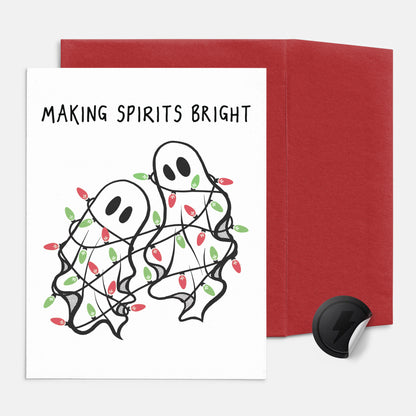 Greeting card with ghosts decorated with Christmas lights and red envelope on white background
